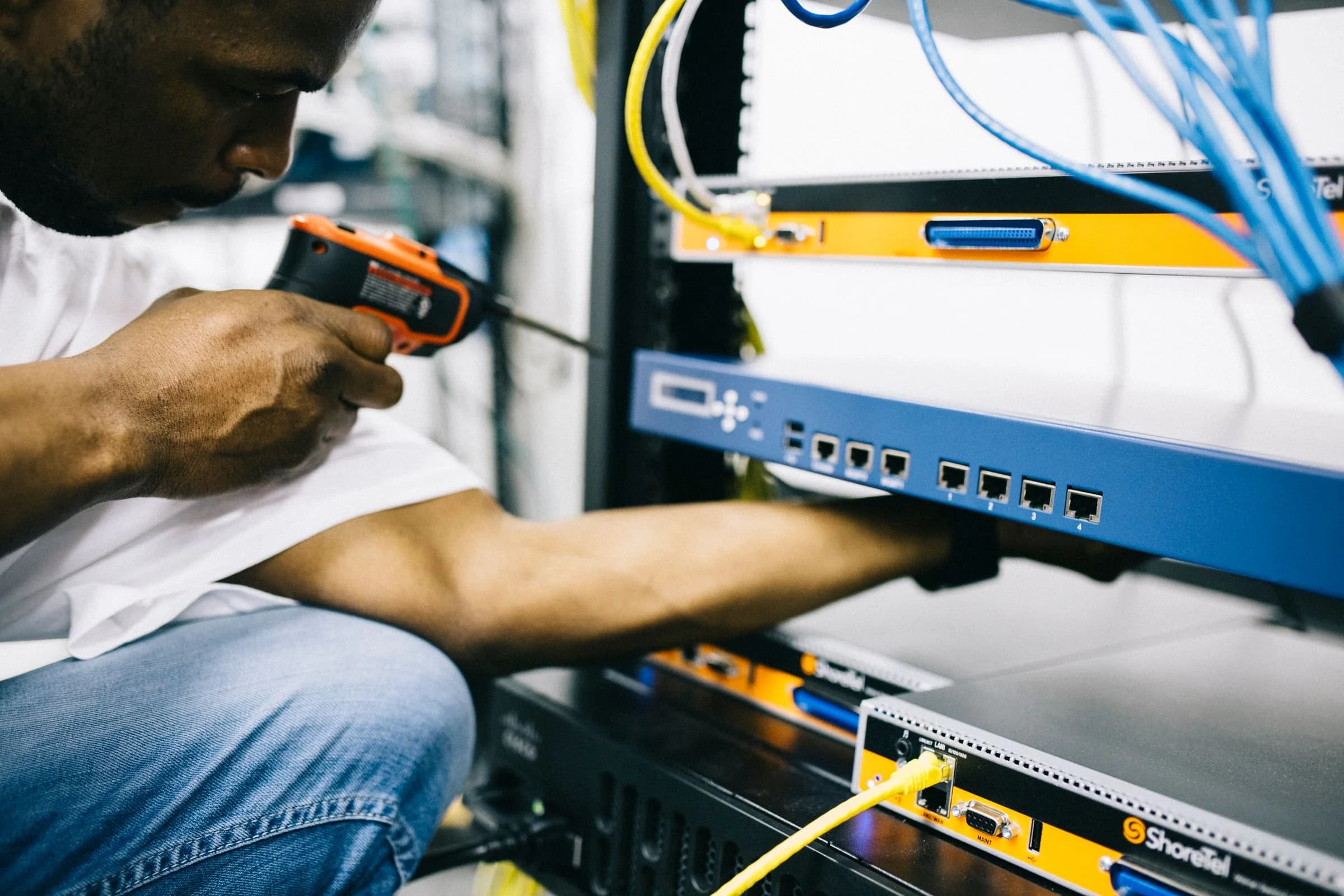 Un technicien intervient sur du matériel et des connexions réseau